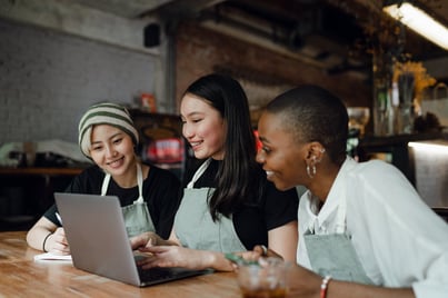 enthusiastic team members working on a laptop together